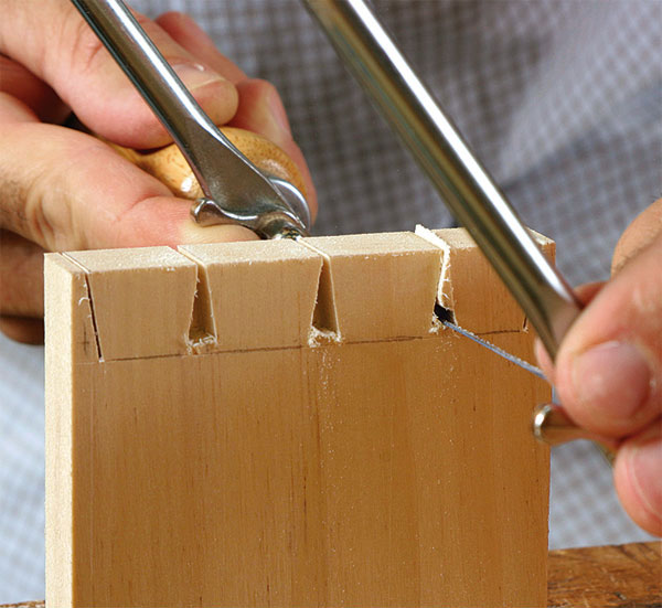 A coping saw cuts out the waste