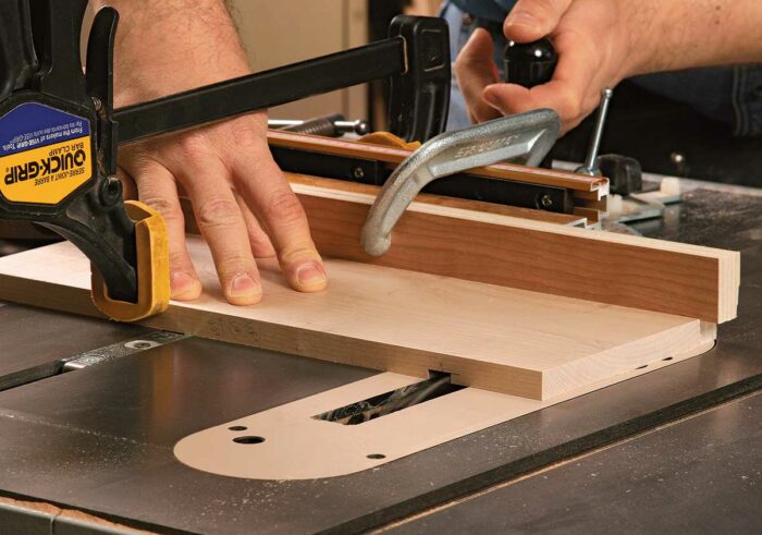 Cut the dado for the back. Restack the dado set to 1/2 in. wide and sneak up on the full depth. Clamp the workpiece to the miter gauge to keep it from drifting.