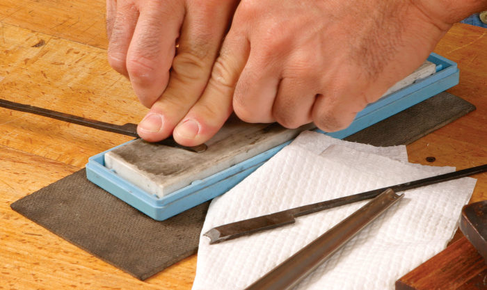 Use a flat sharpening stone to polish the flat side of the blade to a mirror finish.