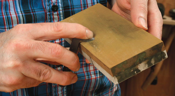 blade in hand to sharpen a router plane blade