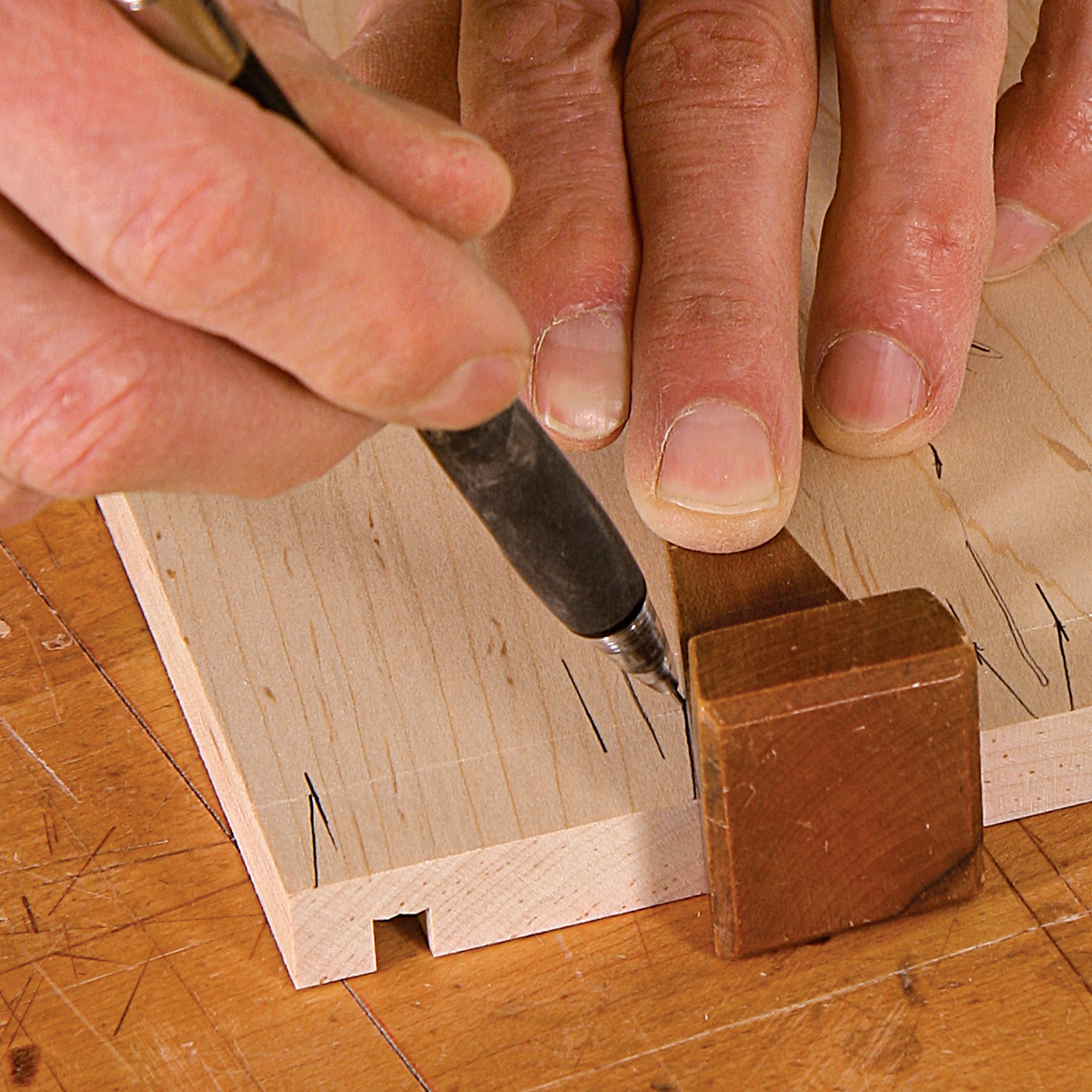 Lay out the tails. Use your normal process to lay out and cut the tails in the drawer sides—they’re no different than in a through-dovetail joint.