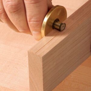 Use a marking gauge for the cheek. Scribe a line in the exact center of the part’s thickness. Mark the end grain as well.