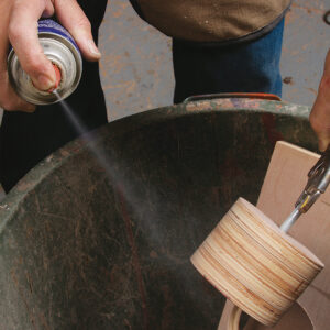 spray a thin coat of adhesive onto the drum and paper