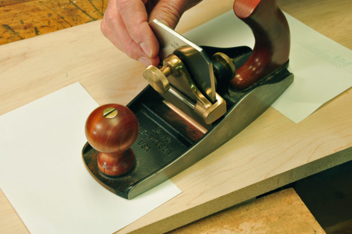 a sheet or two of printer paper under the toe of the plane, drop the blade into the holder pushing it firmly against the bench, and tighten the blade holder.