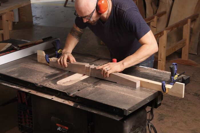 Cut the taper with a bandsaw and clean up the surfaces with a plane and sanding block. Then relieve the bottoms with a dado blade and two stops on the tablesaw.