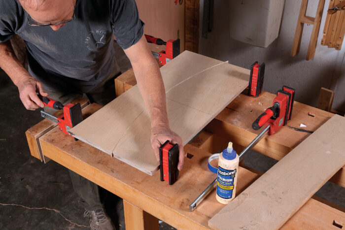 a strip of veneer the same thickness as the kerf of his bandsaw, then glues the veneer to the edge of one of the fences