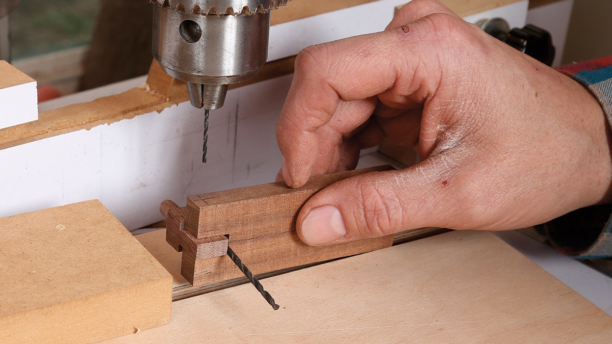 Phillip Morley uses a drill bit to offset the pieces before he drills the pin hole 