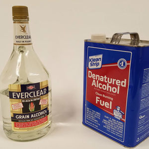 A bottle of grain alcohol next to a gallon of denatured alcohol.