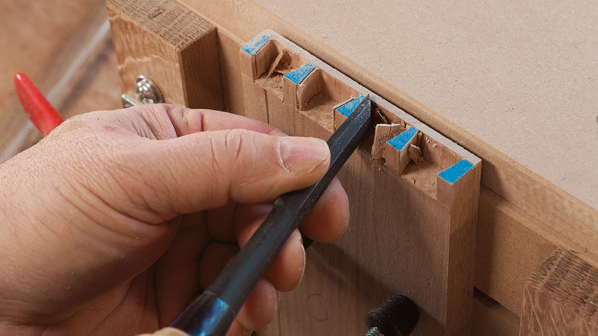 To clean out the waste after routing, start with a fishtail chisel or a pair of skew chisels and sever the end grain into the corners of the sockets where the router bit can’t reach.