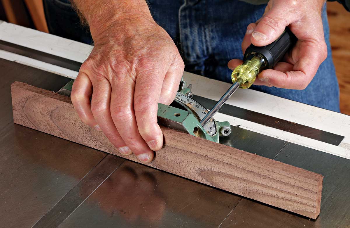 Screw a hardwood fence to the miter gauge. The piece should be milled flat and square. The fence will help prevent chipout and will offer plenty of support as you make the cut.
