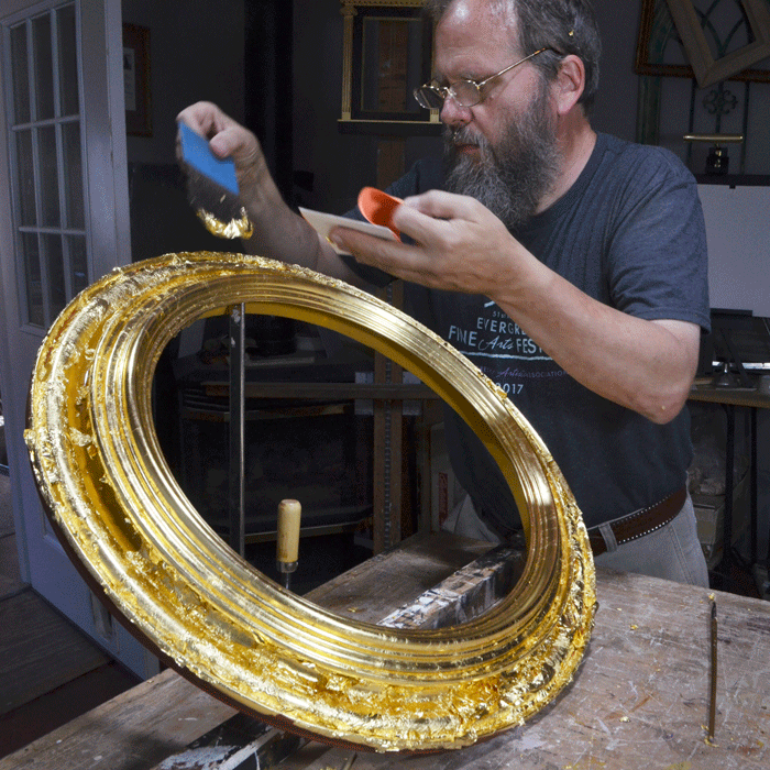 Barrie Lynn Bryant applies gold leaf to one of his turned frames.