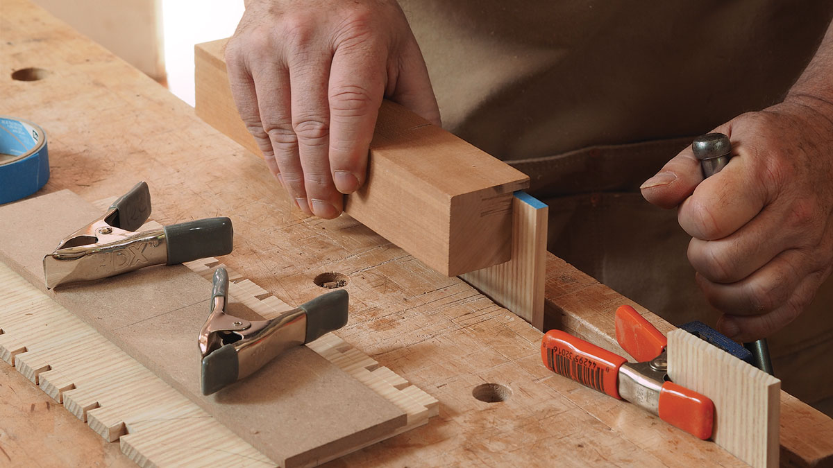 Minimize flex when scribing the pins. Add blue tape on the end grain and clamp the pin board low to the benchtop. If the panel is wider than your vise jaws, clamp the unsupported end to the front edge of the bench.