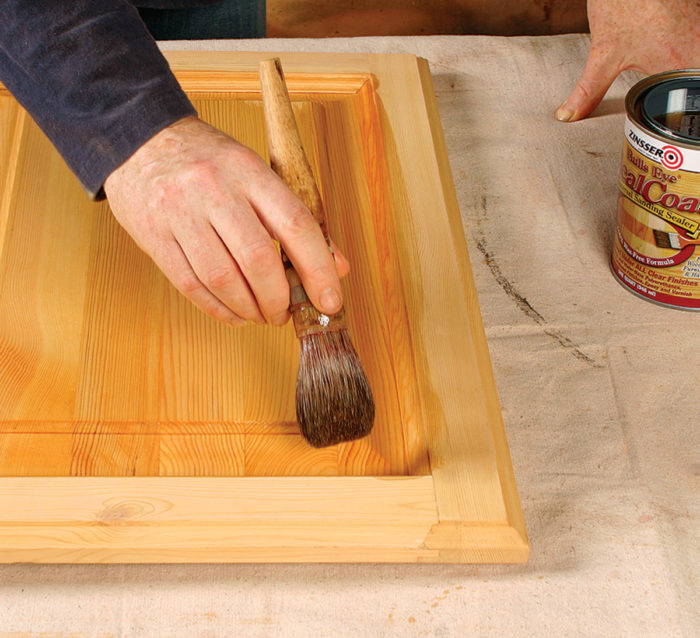 Sealing the stained surface by brushing on a coat of dewaxed shellac.