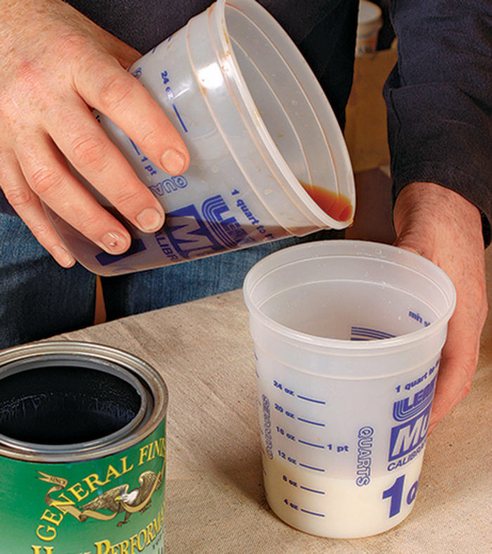 Man pouring tea stain into a clear water based finish to darken the color.