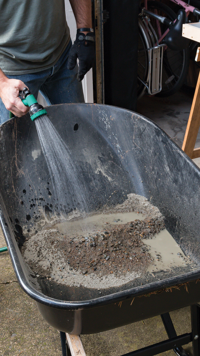 Pour about half a bag of concrete mix into your wheelbarrow or mixing tub and start adding water in small amounts, stirring and blending the mix as you go.