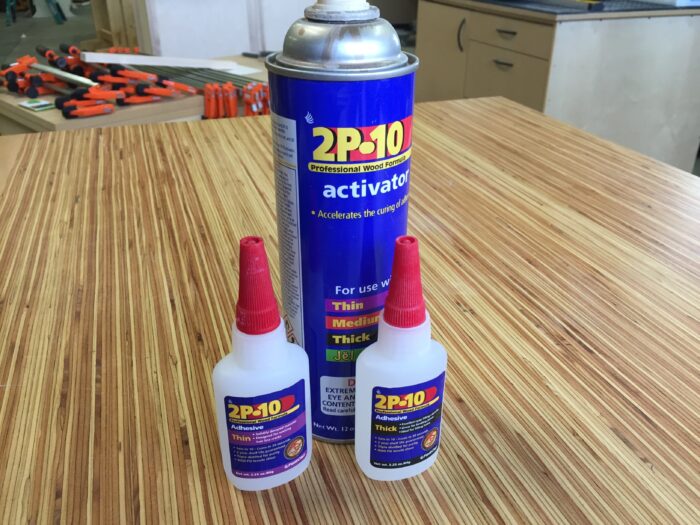 Two bottles of ca glue and a spray can of activator.