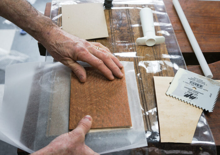 pressing veneer into place with wax paper