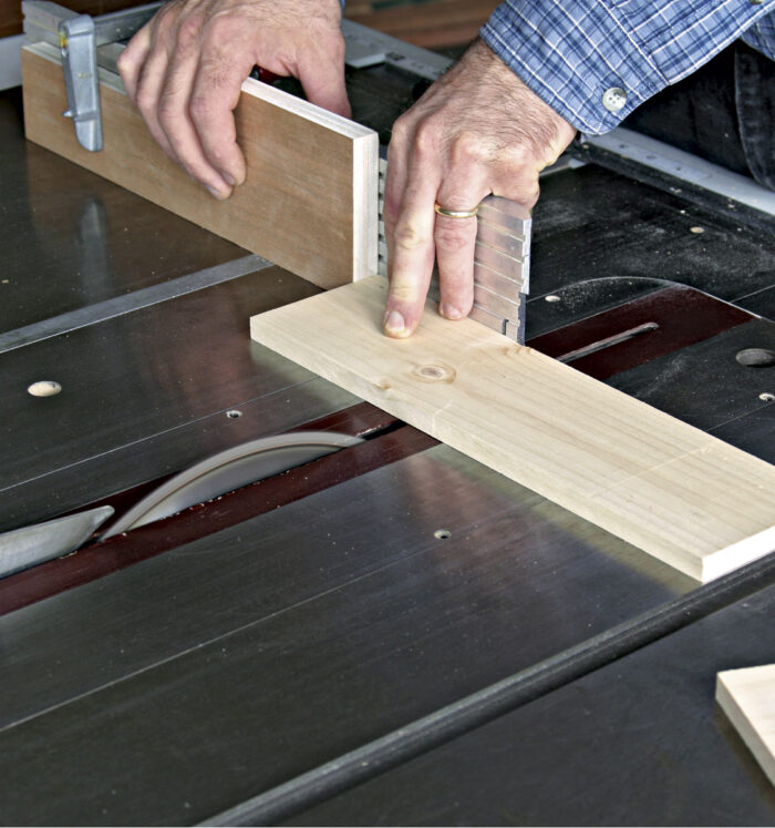 Stop block is clamped to the miter gauge to get the boards the same length.