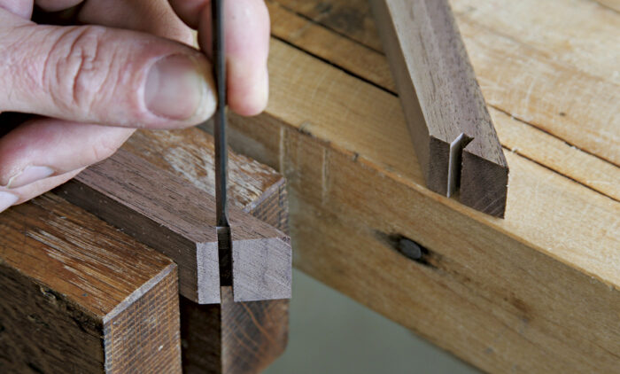 A small chisel is used to flatten the bottom of the spline kerf.