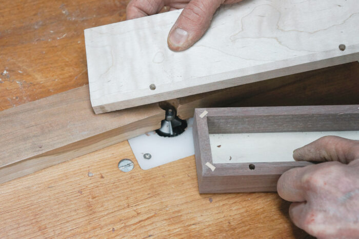 Using a chamfering bit in the router table to make the relief cut in the back edges of the lid and body of the box