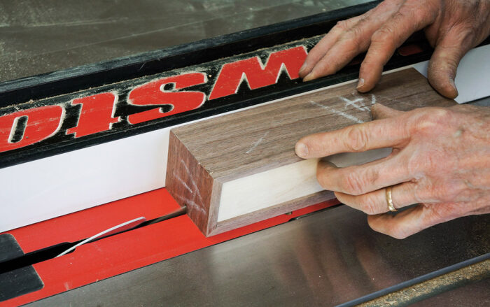 Partially cutting the two boxes apart on the table saw