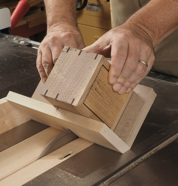 Use a jig that supports the box at 45° to cut slots for splines.