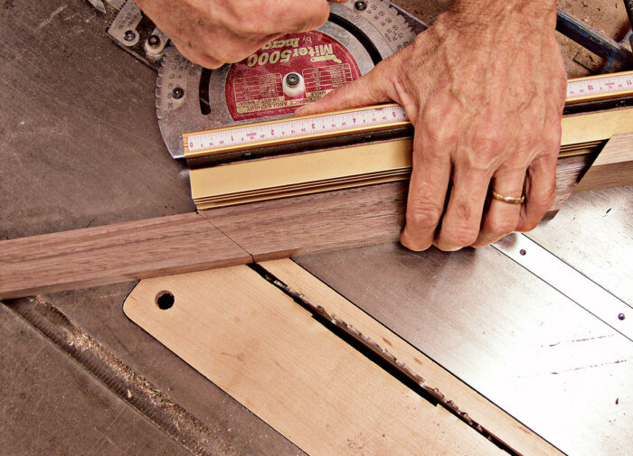 Using a miter gauge on your tablesaw to cut the parts of the base frame to size. 