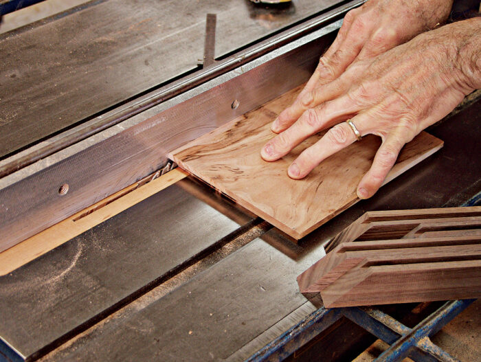 Making cuts into the top face of the top panel to finish forming a tongue that fits into the grooves on the lid frame.