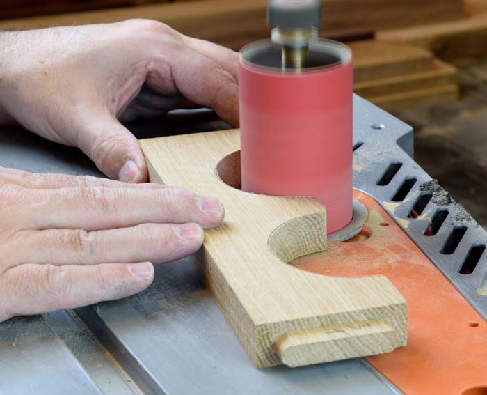 sanding a curve into a wooden piece with a spindle sander