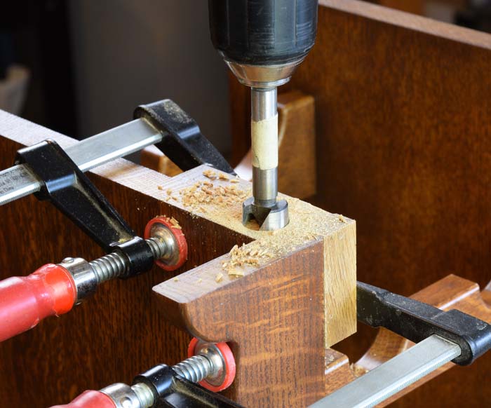 Using a forstner bit to drill into the end grain of the rack for a figure eight fastener