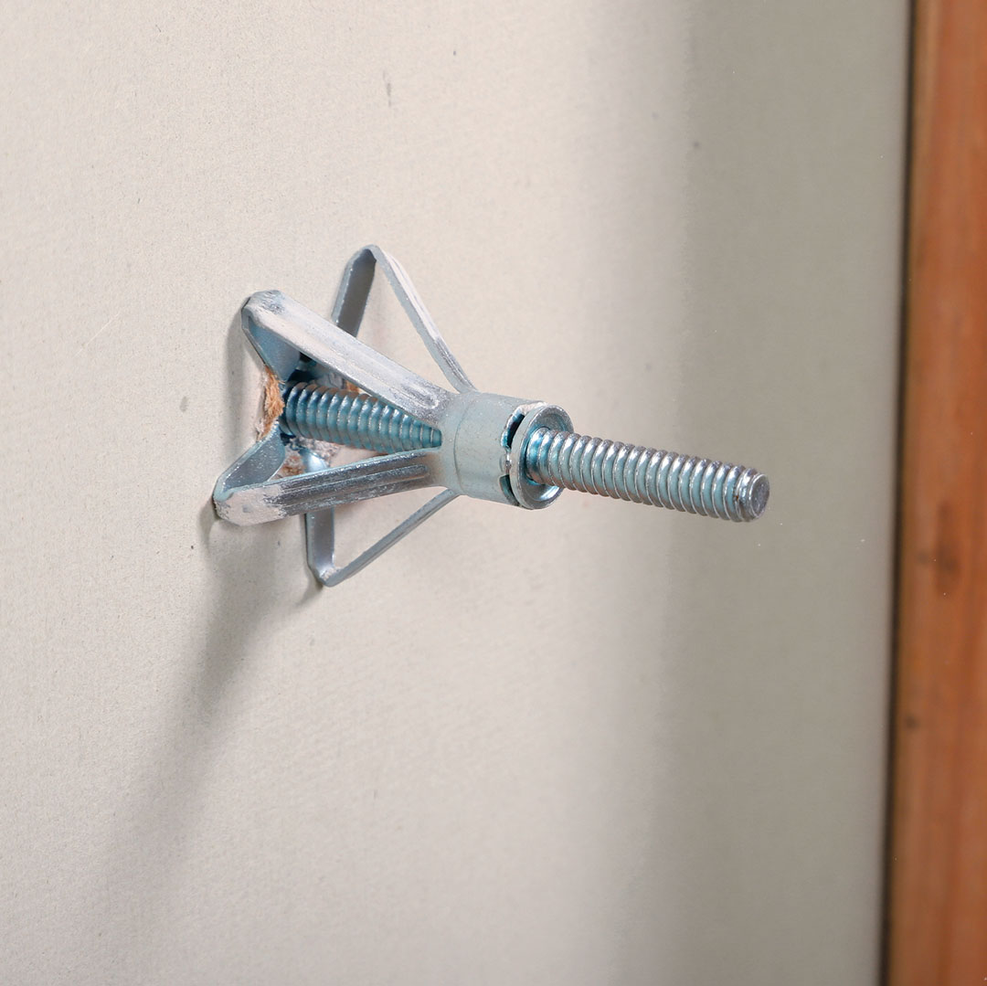 Molly bolts have a slotted sleeve that will spread open behind a hollow wall when you tighten the machine-threaded screw, creating powerful purchase. 