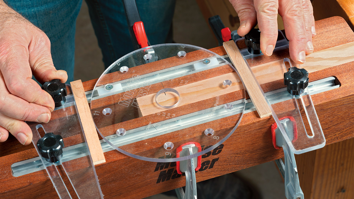 Setup is simple. The router rides on a round polycarbonate slide plate, and two adjustable fences limit its travel. With the slide plate centered, you set the stops by inserting two small shopmade spacers. 