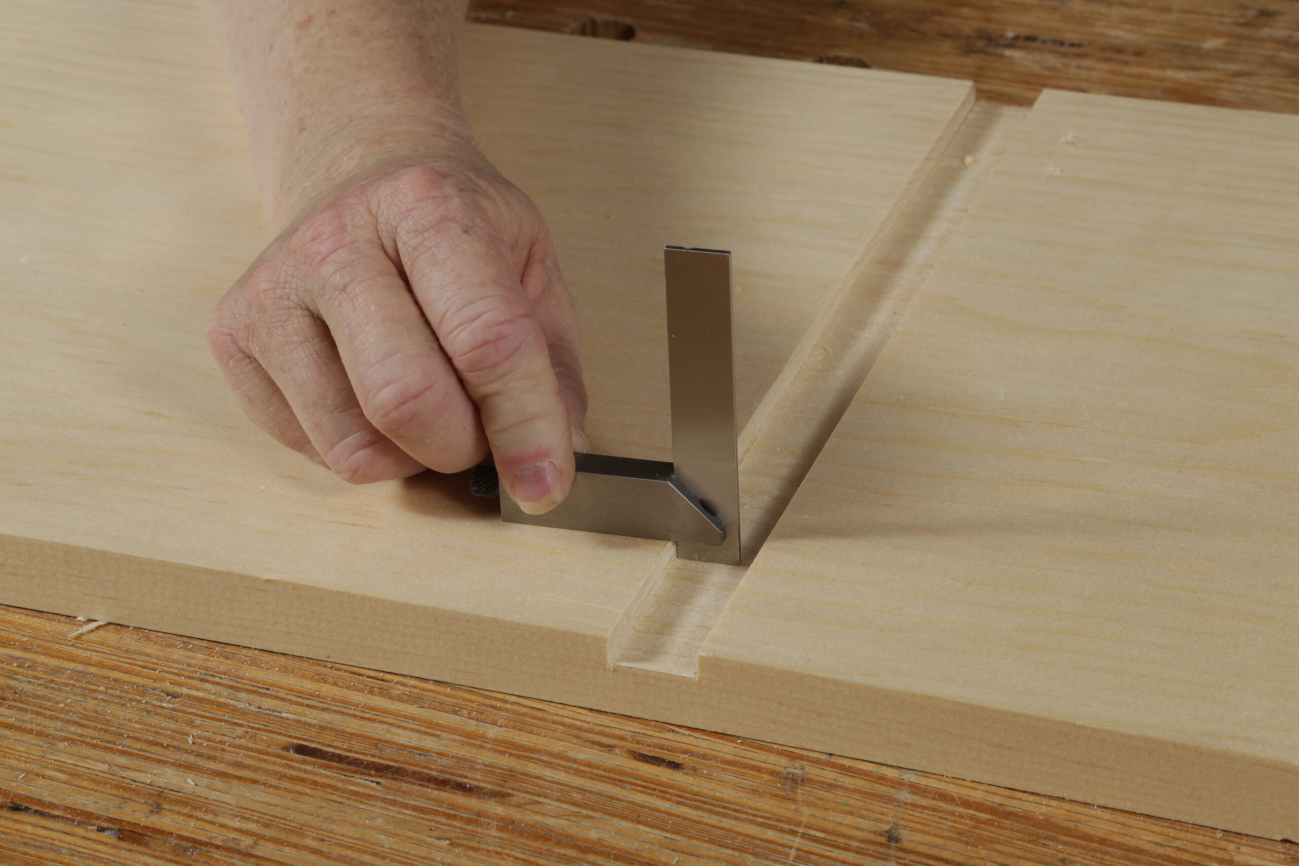 using a small square to verify the dado walls are square and its bottom flat 