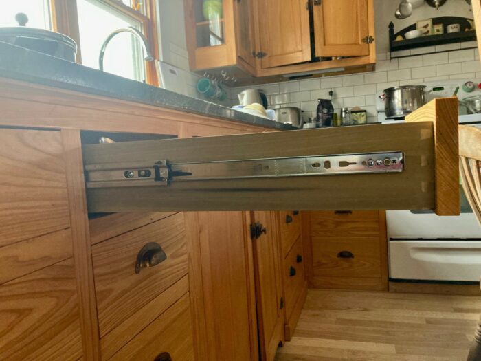 A side mounted kitchen drawer fully extended on ball-bearing slides.