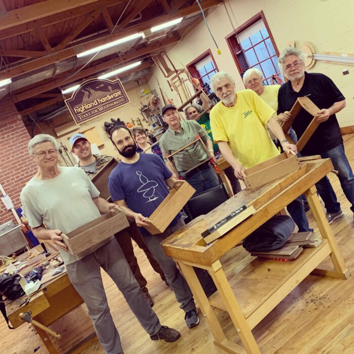 A group of students in a Highland Woodworking class displaying their handmade Shaker trays.