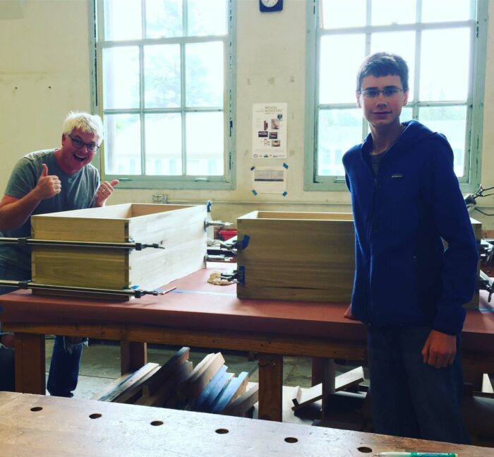 Two students at the Port Townsend School of Woodworking displaying their Shaker boxes.