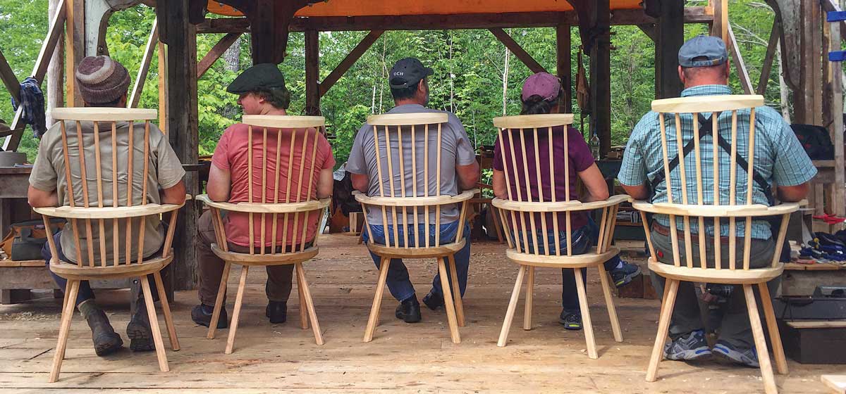 men sitting in wooden chairs