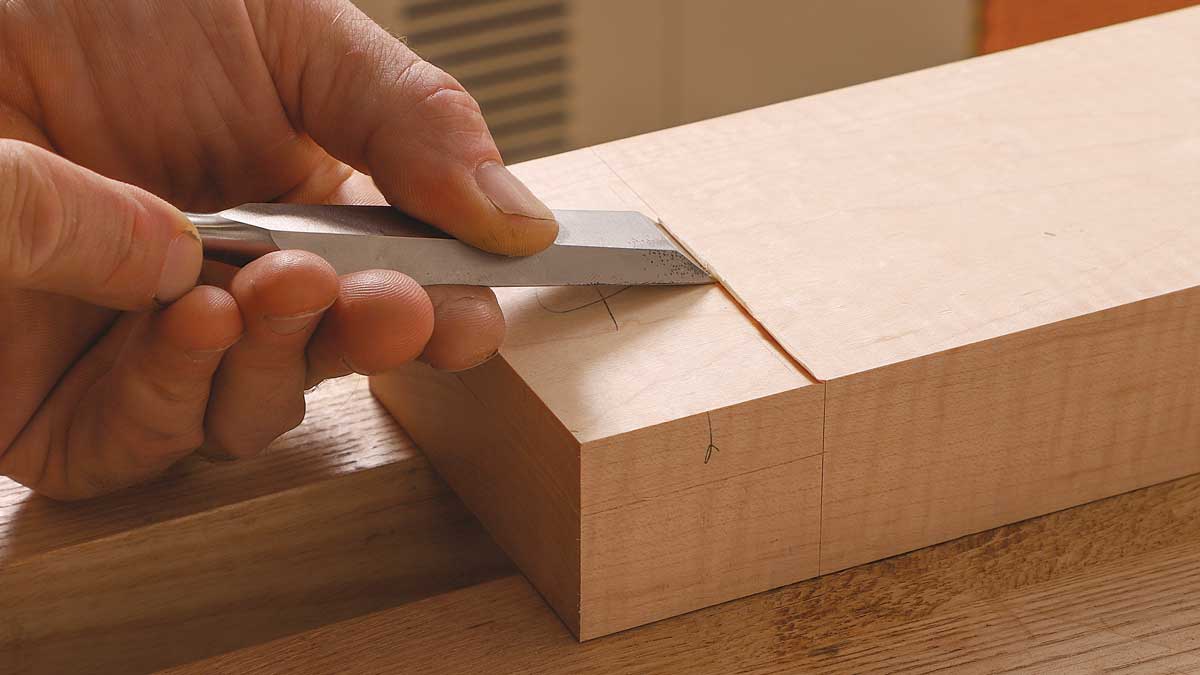 Build a little wall. To prepare for the shoulder cut, scribe the crossgrain layout line with a knife, then use a chisel to create a stop to guide your saw.