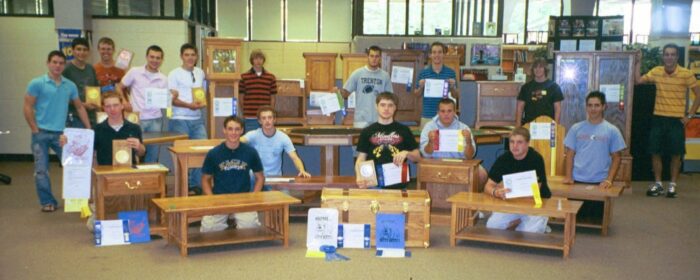 A group of students with woodworking projects