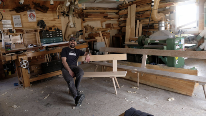 Jameel Abraham poses with the Amana Church Bench he built.