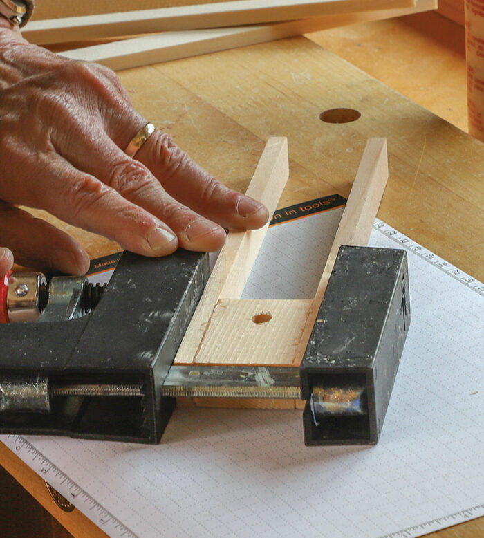McIvor glues two slats to a block pre-drilled for the T-bolt