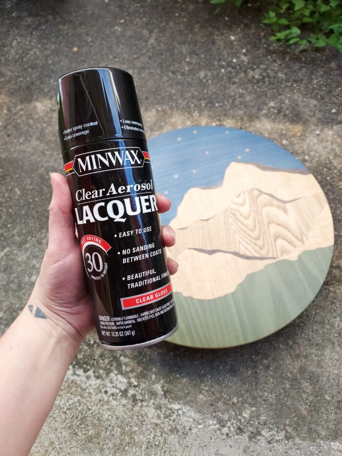 A can of Minwax Clear Aerosol Lacquer next to Chelsea Van Voorhis' work of veneer art.