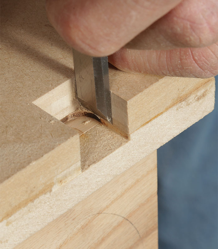 Jig guides the chisel when squaring the routed hinge mortise