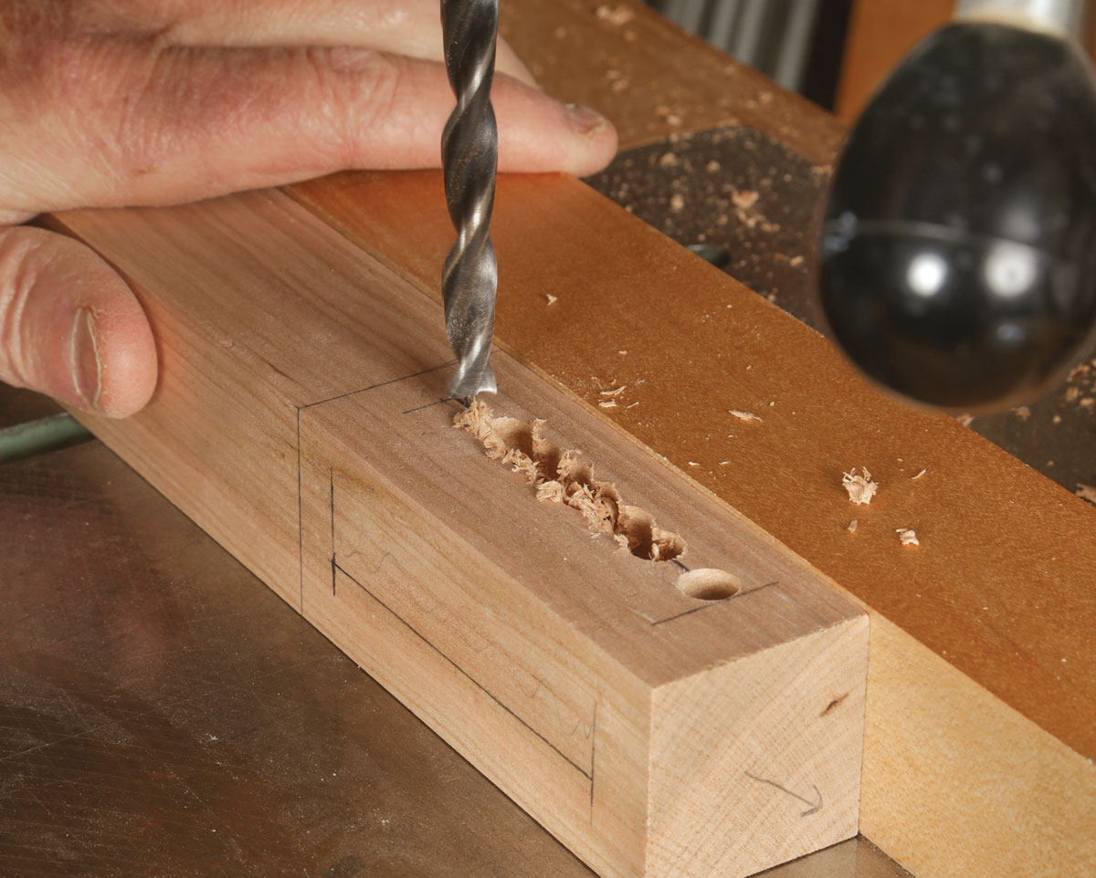 Drill press accurately excavates most of the waste. These holes go a long way to starting straight, even walls. Overlap the holes as you march down the mortise. 