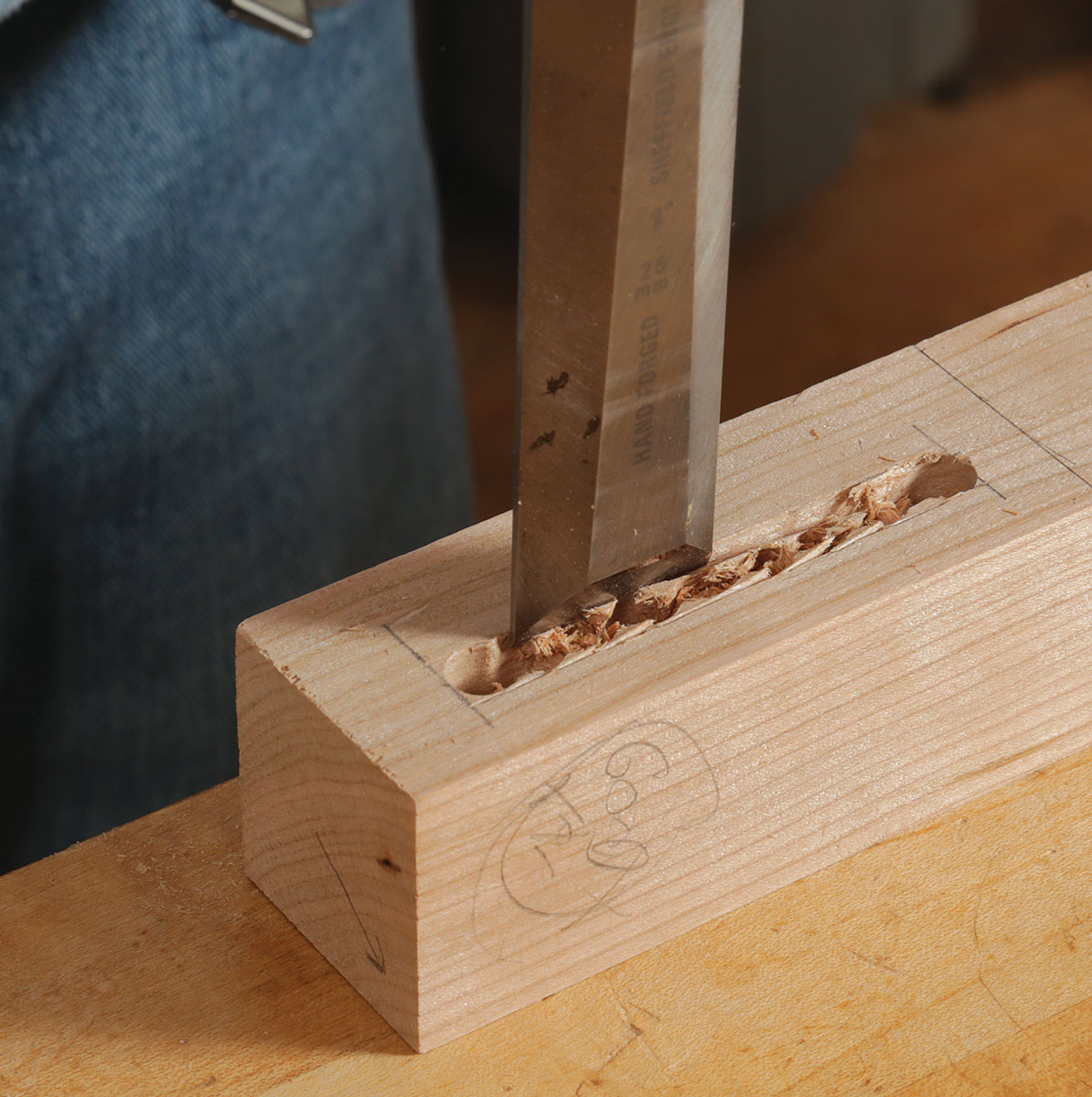 Finish with a chisel. Take careful paring cuts to remove the peaks between the drilled holes. Chop the ends square, too. Be careful near the fragile short grain at the top end. 