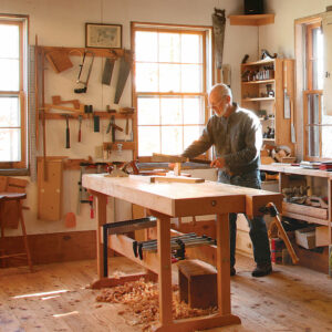 Charlie Durfee standing by his workbench in the his woodshop