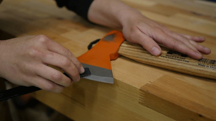 sanding the bevel of a carving ax
