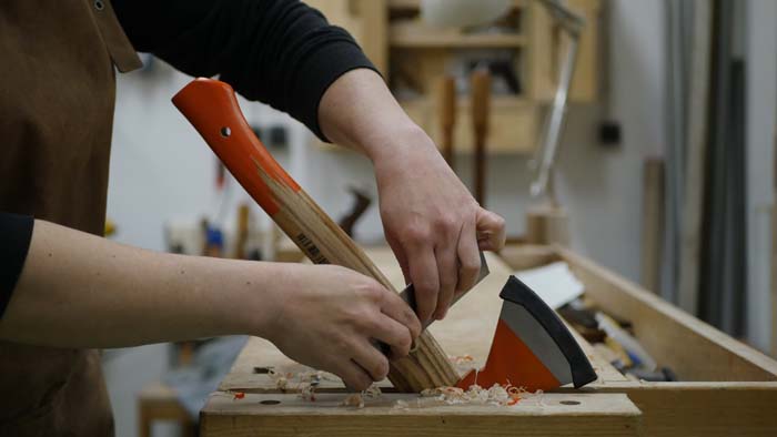 sanding the bevel of a carving ax