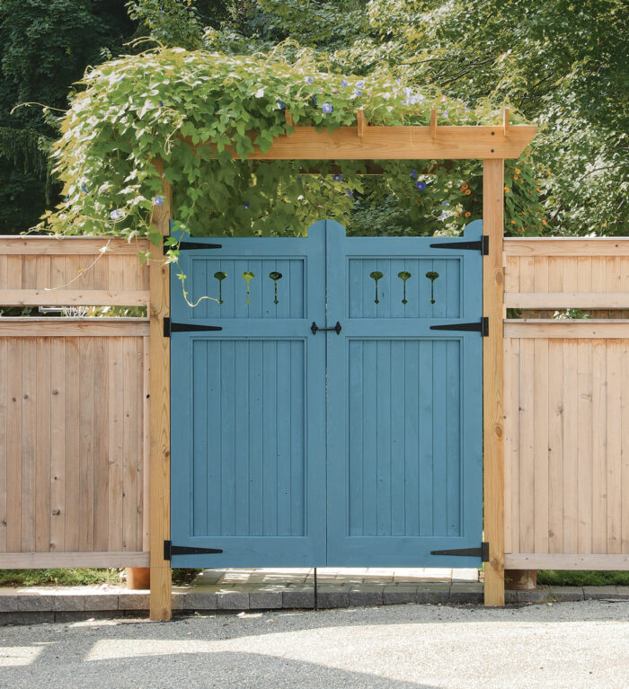 Perforated panels. Utilizing the same heavy-duty mortise-and-tenon door frame, Hartman filled this painted gate with tongue-and-groove panels, scroll-sawing decorative cutouts between the upper slats. These panels provide more privacy.
