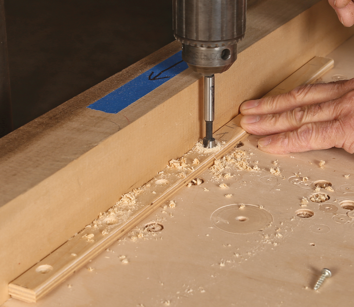 Prep the runners for screws. At the drill press, add a counterbore with a Forstner bit, and finish with a 1⁄8-in. bit as a pilot hole as well as a clearance hole.